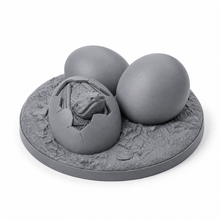 3D-printet quest-objekt med tre dragegg, ett i ferd med å klekkes, i grå PLA til D&D og Pathfinder.