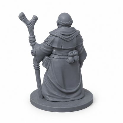 3D-printet Landsbyvismann med kappe, vandrestav, symbol og reiseutstyr i grå PLA til D&D og tabletop-rollespill.